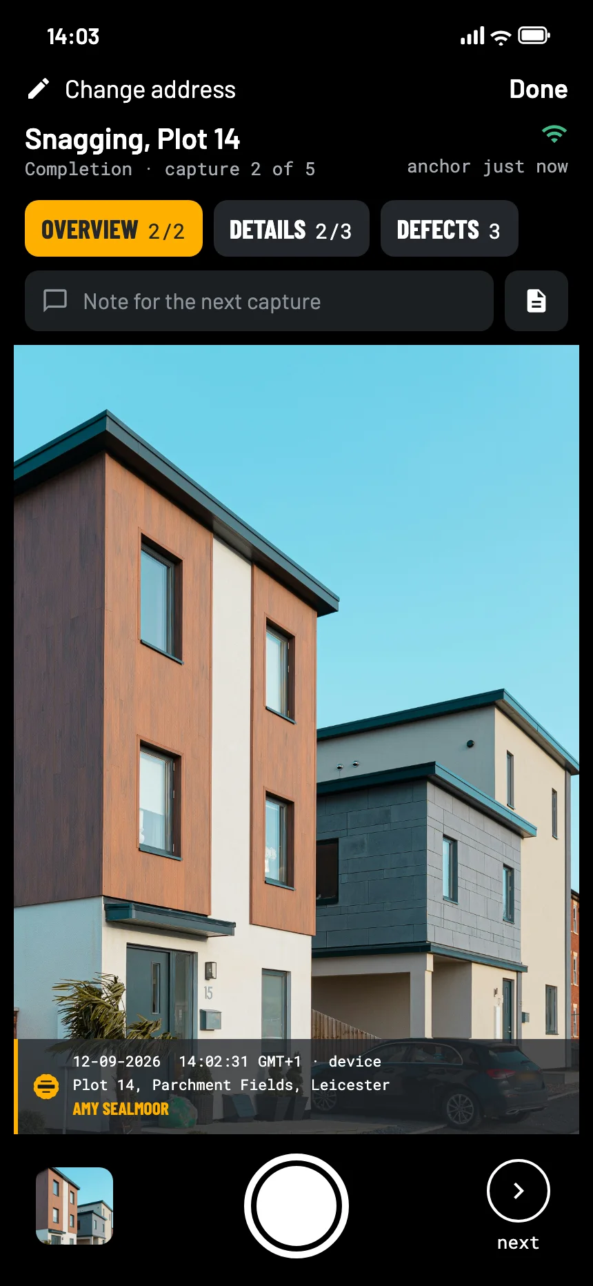 The EverStamp camera at the handover of a new home: the front of the house in the viewfinder, with the stamp bar in the picture