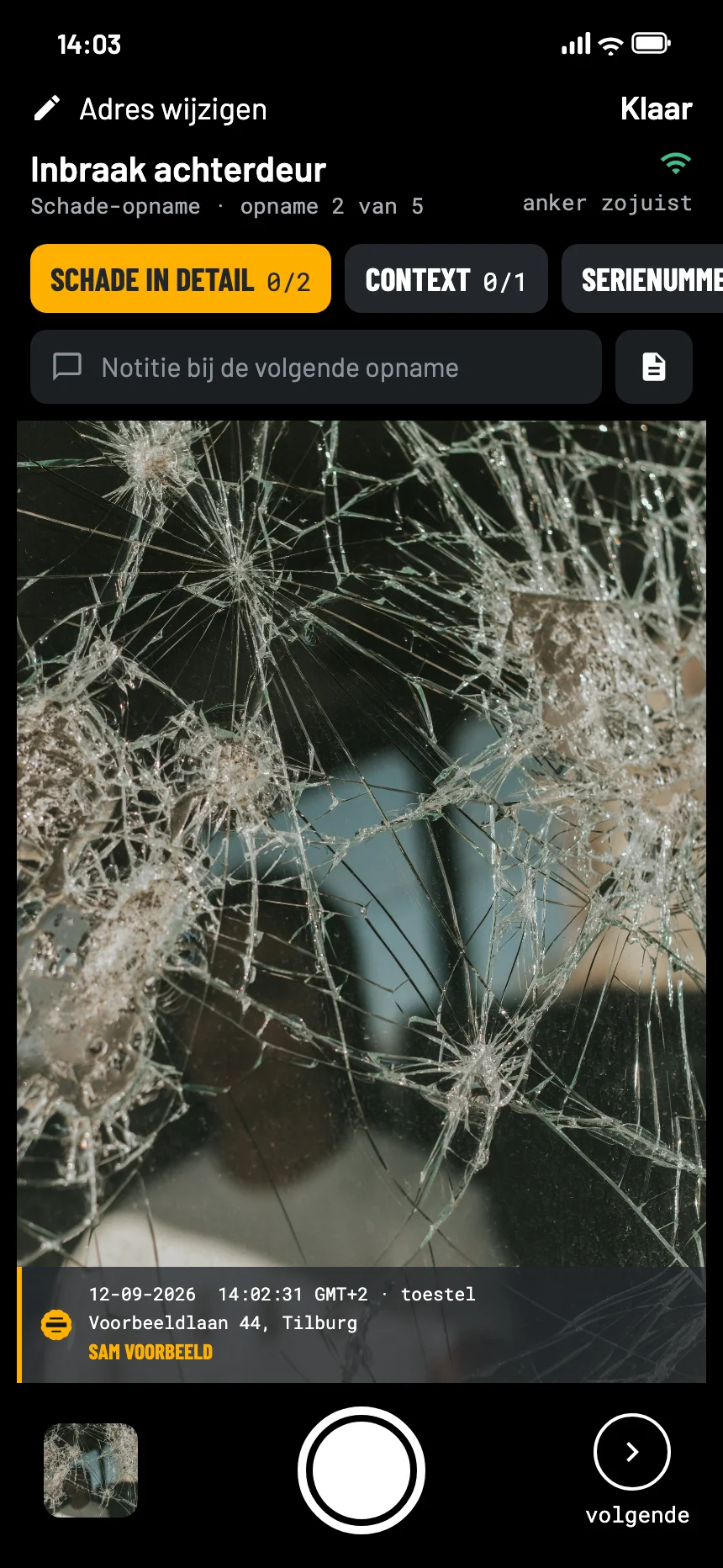 De camera van EverStamp bij een schademelding na een inbraak: de ingeslagen ruit van dichtbij in de zoeker, met de stempelbalk in beeld